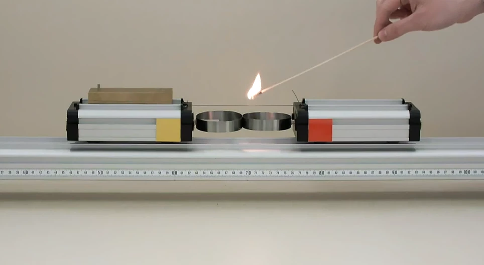 Hai chiếc xe có khối lượng khác nhau được đẩy ra xa nhau bởi một lò xo